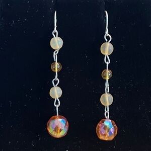 Handcrafted silver tone earrings with amber colored beads.
